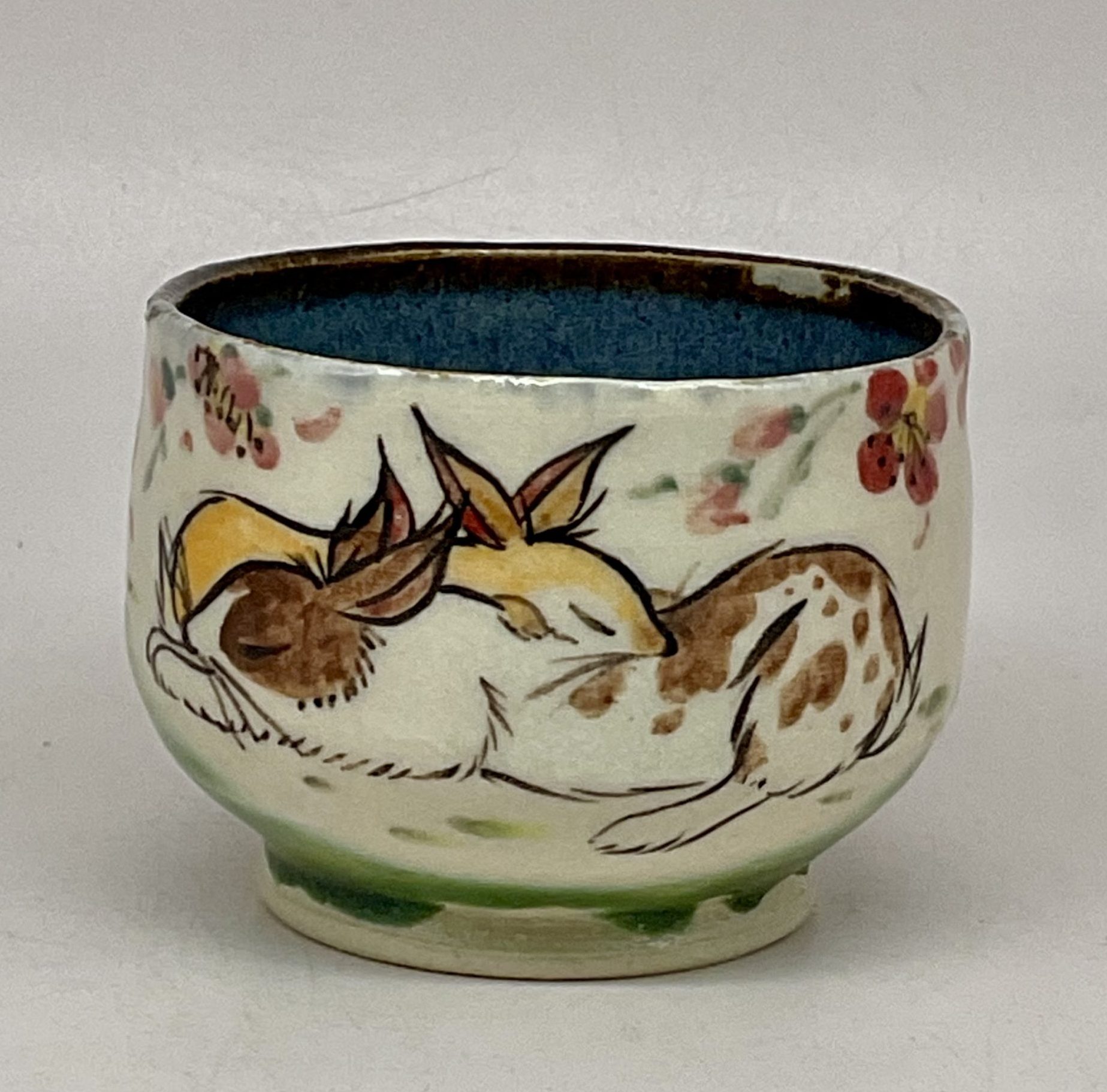 Stoneware cup handpainted with rabbits